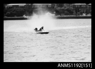 Black and white negative number 15 depicting power boat completing a turn