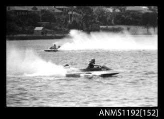 Black and white negative number 16 depicting power boats entering and completing their turns