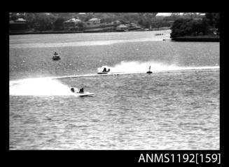Black and white negative number 23 depicting two power boats at speed, turning at marker buoy