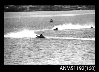 Black and white negative number 24 depicting two power boats at speed, turning at marker buoy