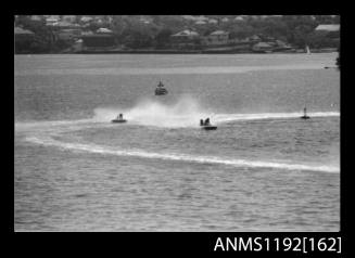 Black and white negative number 26 depicting two power boats at speed, turning at marker buoy