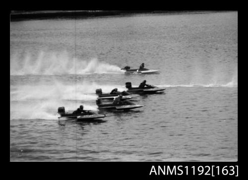 Black and white negative number 27 depicting four power boats at speed, almost neck to neck