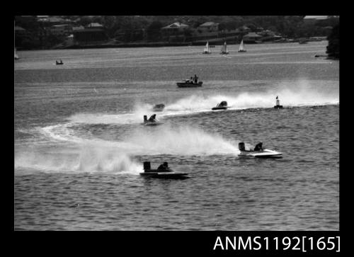 Black and white negative number 29 depicting four power boats turning at marker buoy