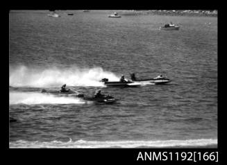 Black and white negative number 30 depicting 4 power boats at speed