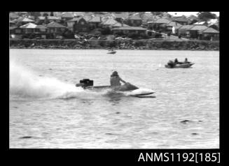 Black and white negative number 18 depicting power boat at speed  starboard side view at outboard engined hydroplane titles, Cabarita, Parramatta River, Sydney, New South Wales