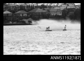 Black and white negative number 20 depicting power boat completing a turn at marker buoy