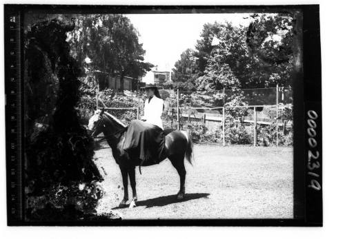 Portrait of a woman seated sidesaddle on a horse