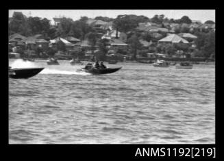 Black and white negative number 11 depicting power boat with driver and co-driver at speed