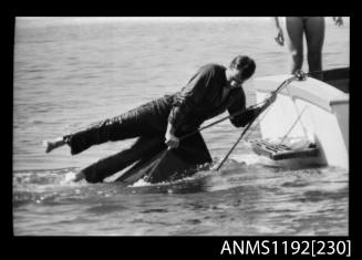 Black and white negative number 2A depicting man hanging on to a rope which is towing the sunken He15n