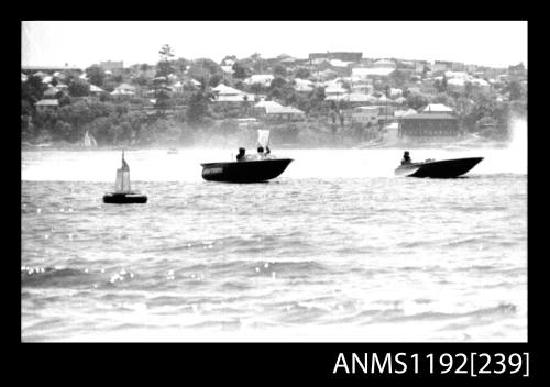 Black and white negative number 11 depicting two power boats stationary near a marker buoy