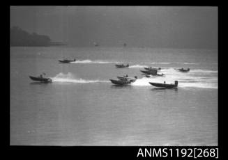 Black and white negative number 11A depicting view of 11 open power boats at speed, most with outboard engine