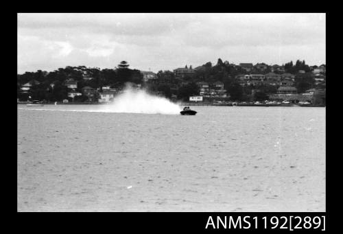 Black and white negative number 17A depicting power boat at speed  Bow-on view at time trials at St George Motor Boat Club, Georges River, Sans Souci, Sydney, New South Wales