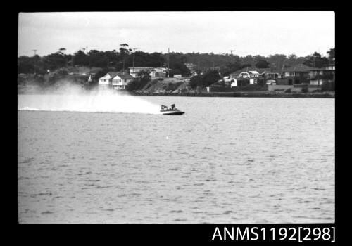 Black and white negative number 26A depicting power boat at speed  Bow/ starboard side view at time trials at St George Motor Boat Club, Georges River, Sans Souci, Sydney, New South Wales