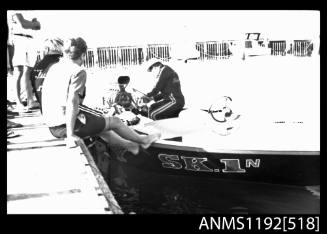 Black and white negative number 5 depicting view of man working on a v-8 petrol inboard engine of S k