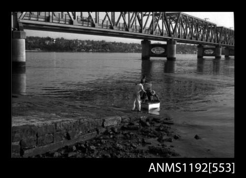 Black and white negative number 9A depicting view of open power boat afloat at end of launching pad