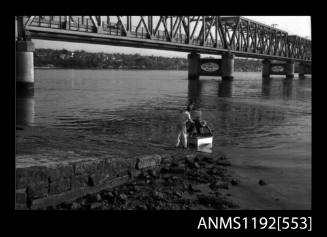 Black and white negative number 9A depicting view of open power boat afloat at end of launching pad