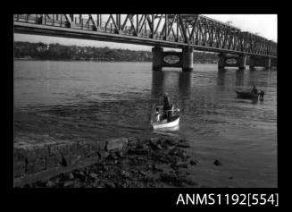 Black and white negative number 10A depicting view of open power boat at end of launching pad, second boat can be seen in the background