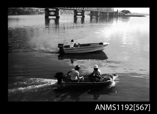 Black and white negative number 23A depicting view small runabout with Mercury outboard engine and two men seated