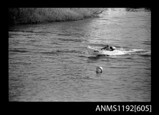 Black and white negative number 6A depicting view MB79N power boat with outboard engine, at speed, elevated port side view