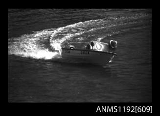 Black and white negative number 10A depicting view of Tyson Gn62k power boat with outboard engine turning at marker buoy, starboard view