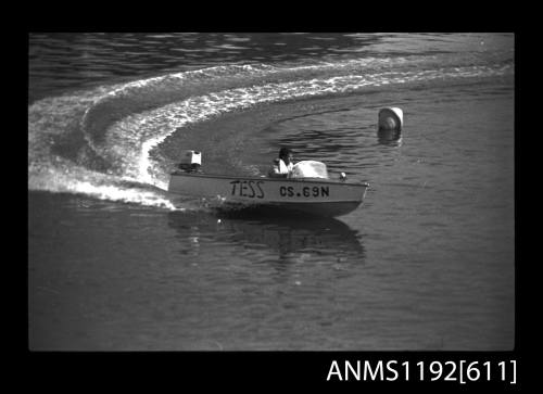 Black and white negative number 12A depicting view of Tess Cs69n power boat with outboard engine, at speed turning at marker buoy