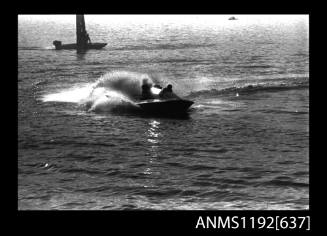 Black and white negative number 19A depicting view of power boat at speed completing a turn, bow/ starboard side view