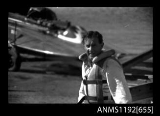 Black and white negative number 10A depicting view of man at boat ramp wearing safety suit