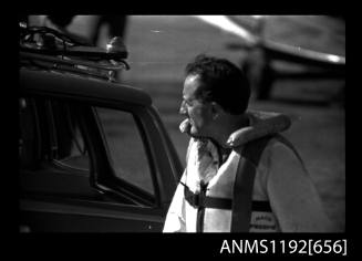 Black and white negative number 11A depicting view of man at boat ramp wearing safety suit