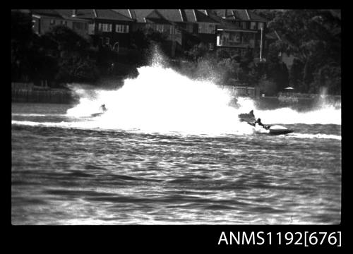 Black and white negative number 31A depicting view of two hydroplanes almost hidden by spray making their turn at marker buoy