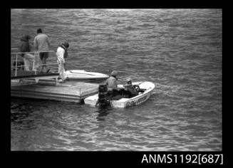 Black and white negative number 16 depicting view of HUNTER, open power boat, outboard engine, with unidentified open power boat