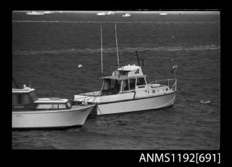 Black and white negative number 20 depicting view of two unidentified cabin cruisers moored midstream