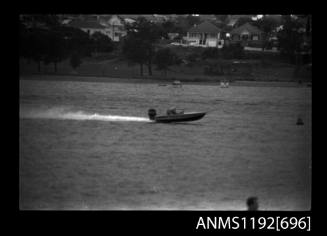 Black and white negative number 25 depicting view of unidentified open power boat, outboard engine, at speed