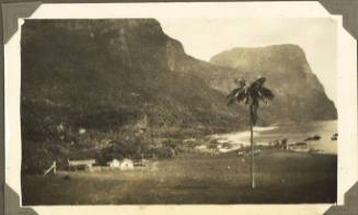 Houses beneath a double peaked mountain