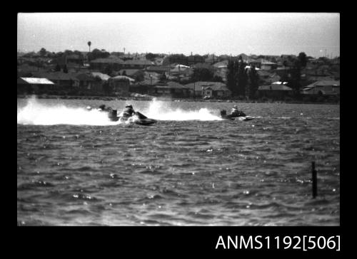 Black and white negative number 25 depicting view of three hydroplanes at speed