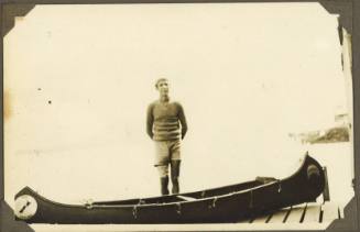 A man standing behind a canoe