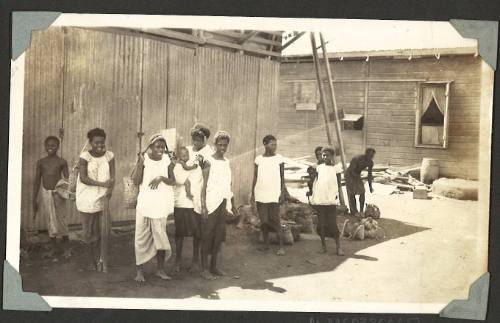 A group of islanders standing in front of a shack