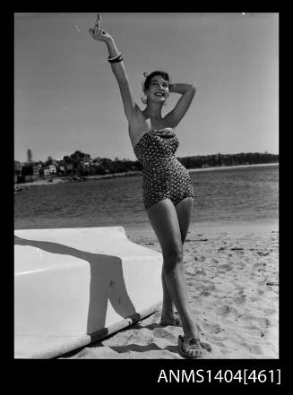 Photographic negative of a swimsuit model posing on a beach