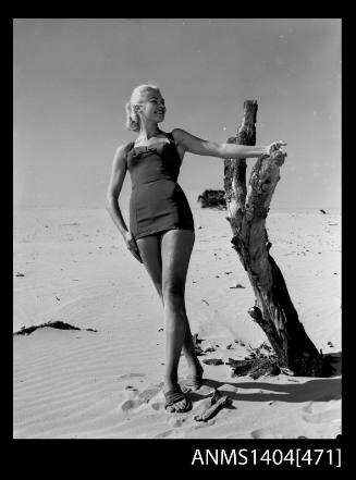 Photographic negative of swimsuit model posing on a sand dune