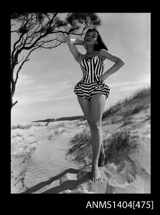 Photographic negative of swimsuit model posing on a  sand dune