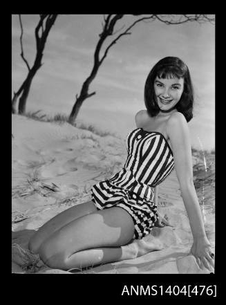 Photographic negative of swimsuit model posing on a sand dune