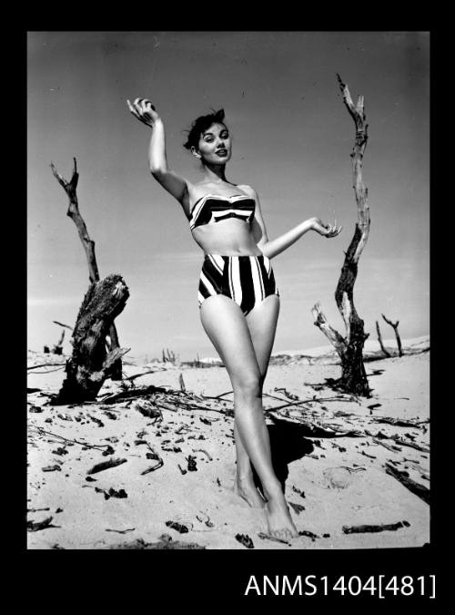 Photographic negative of swimsuit model posing on a beach in a bikini