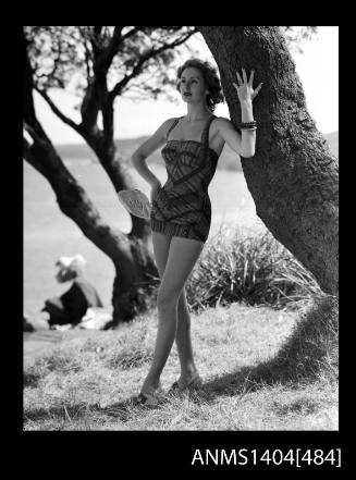 Photographic negative of swimsuit model posing with tree