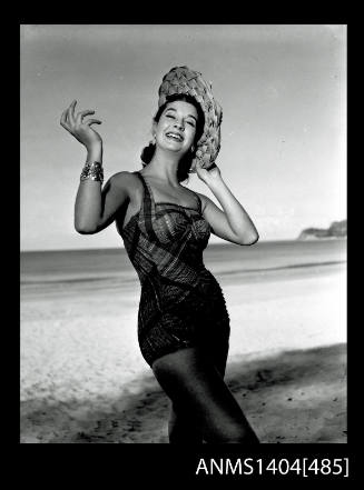 Photographic negative of swimsuit model posing on a beach