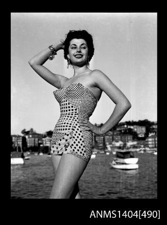 Photographic negative of swimsuit model posing on a wharf