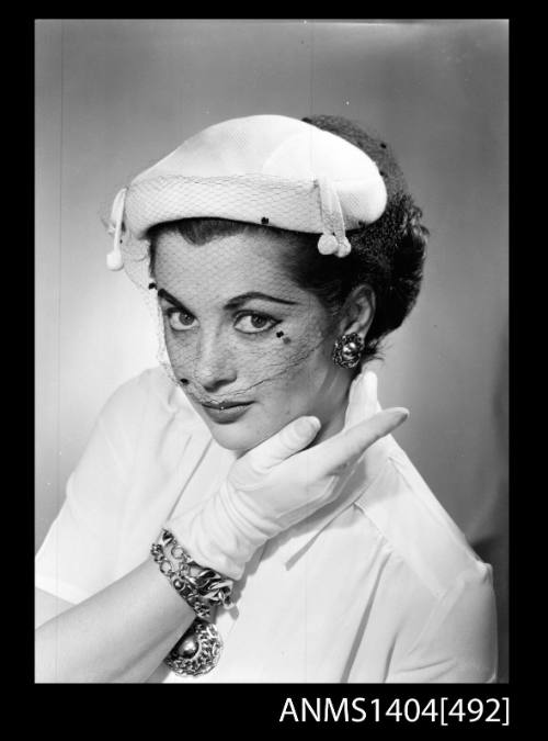 Photographic negative of a model posing with hat and gloves