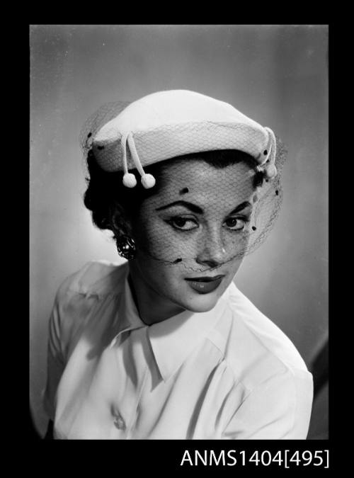 Photographic negative of a model posing with a hat