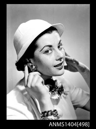 Photographic negative of a model posing with hat and jewellery