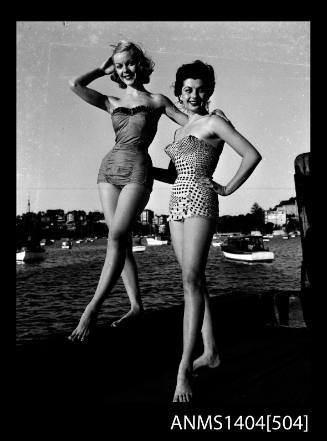 Photographic negative of two swimsuit models posing on a wharf