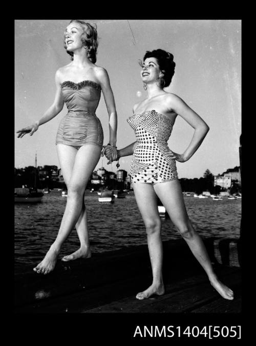 Photographic negative of two swimsuit models posing on a wharf