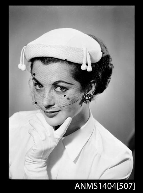 Photographic negative of a model posing with a hat and gloves